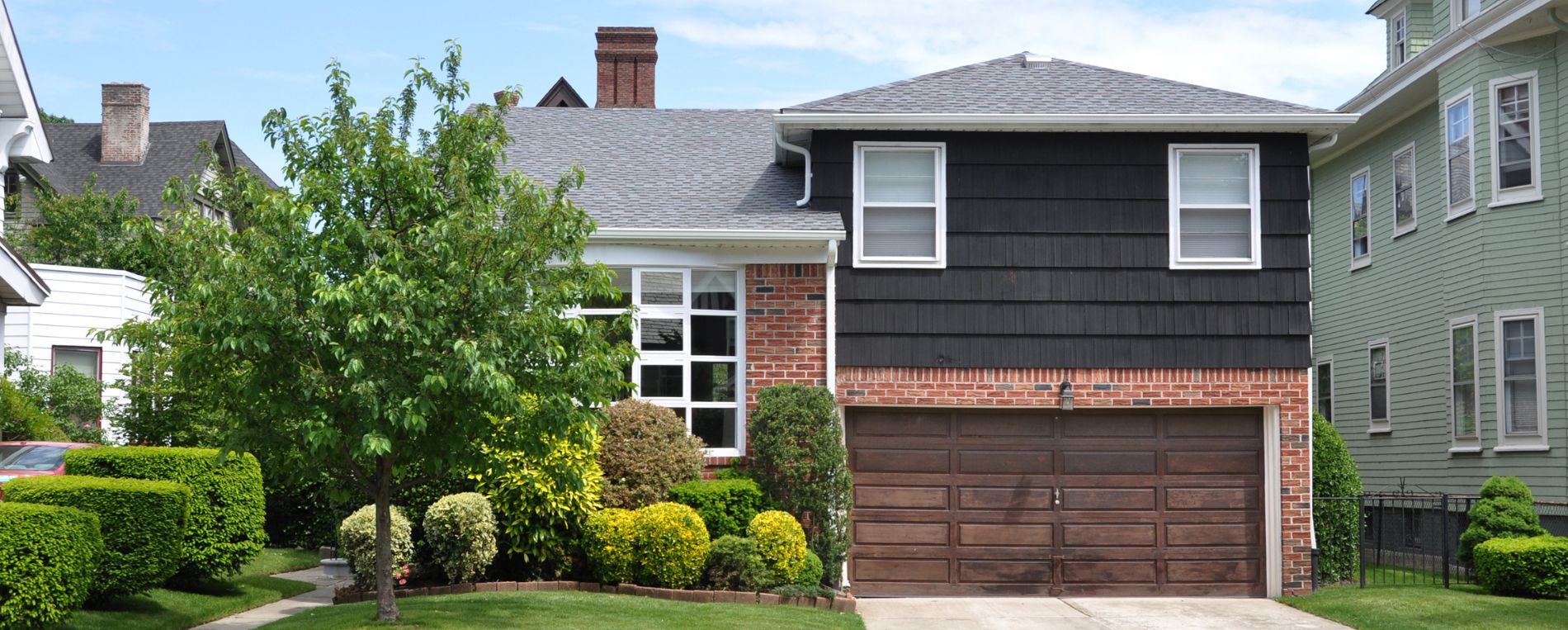 Front view of a residential home with a wooden garage door in Alpine, CA