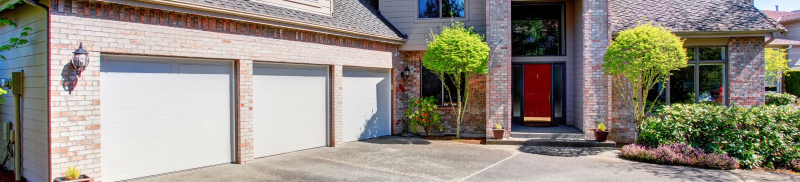 Modern brick home with three automatic garage doors installed by Garage Door Repair Alpine